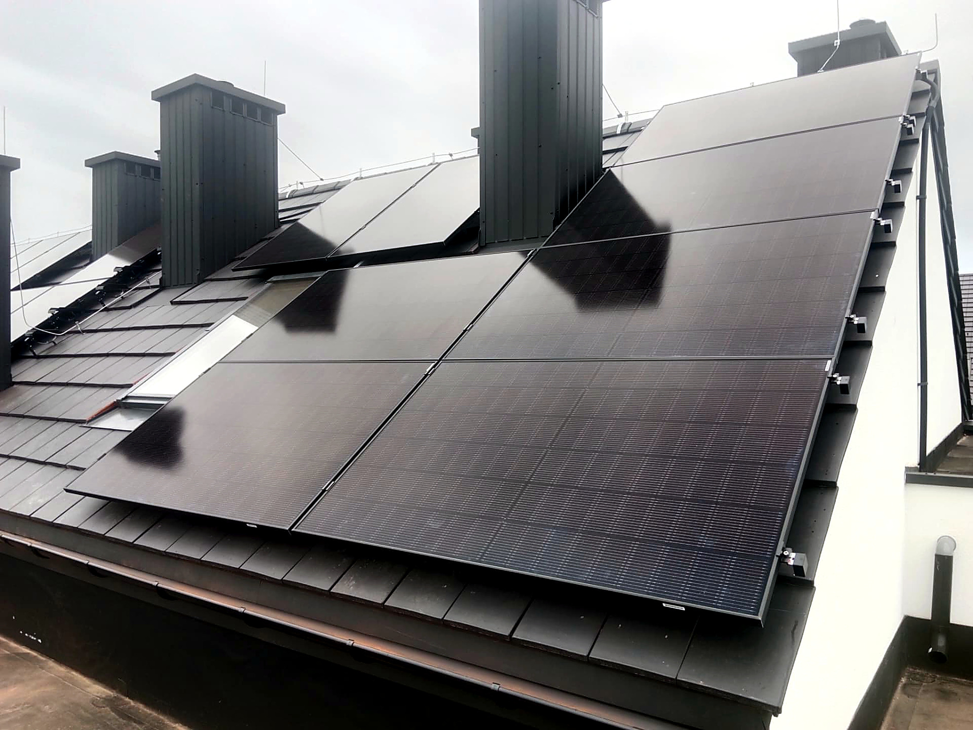 Instalacja full black na dachu z dachówką — montaż wokół kominów